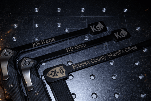 Engraved Outstick for K9 training, featuring names K9 Kane and K9 Bom, plus Brooke County Sheriff's Office branding.